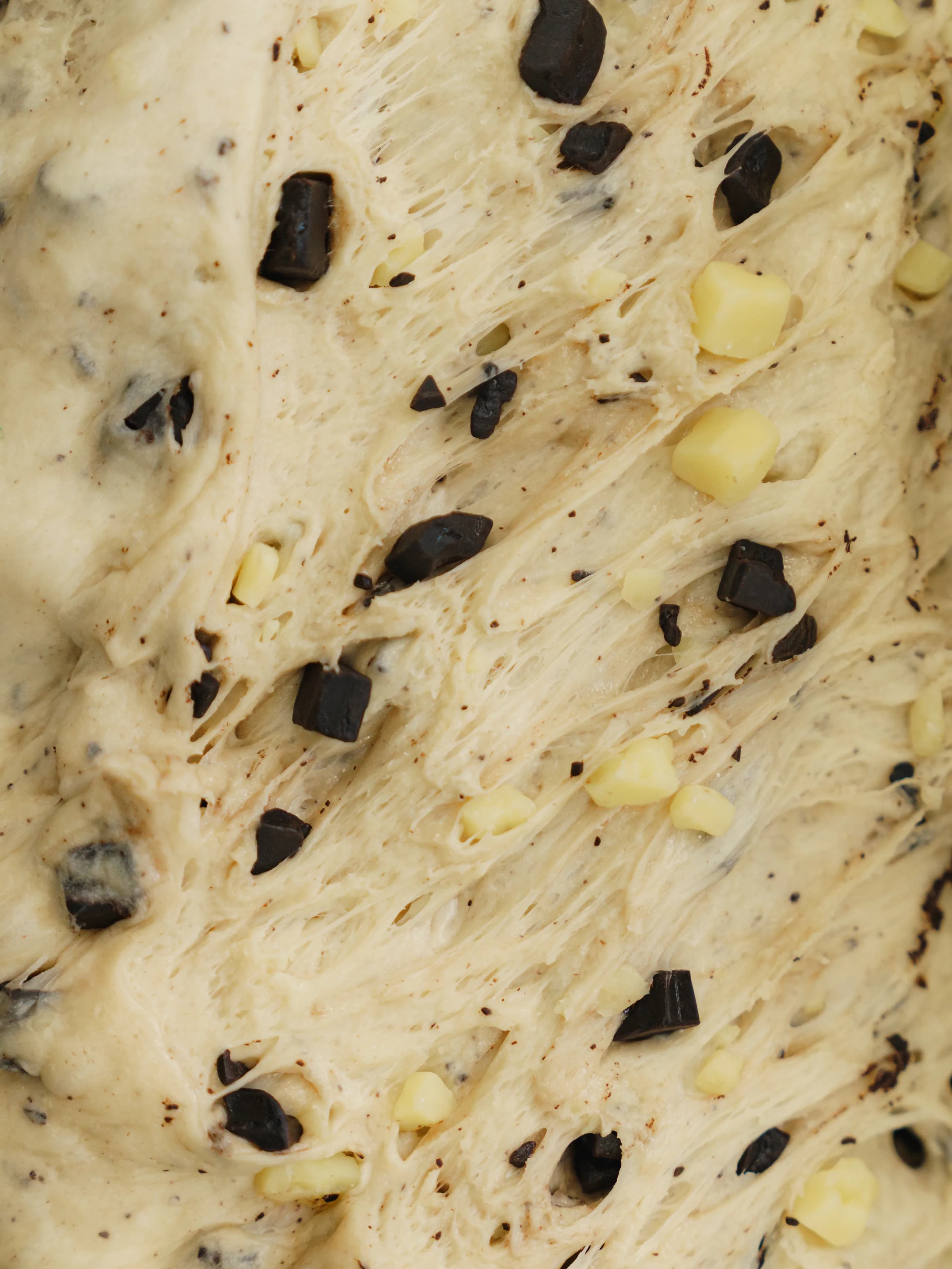 Dough pulled open to show the dark and white chocolate chunks worked through it